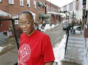 AP Photo/Keith SrakocicSharon Edge stands by the house in Pittsburgh last month where she and her late boyfriend, Curtis Mitchell, lived. 