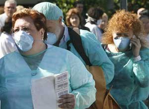 AP Photo/Alberto Saiz A medical staff member, left, leads two patients who are undergoing tests for the swine flu virus at a hospital in Valencia, Spain. 
