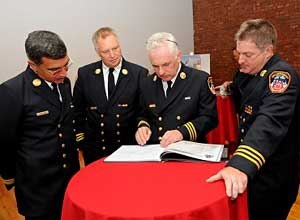 Photo FDNYChiefs Marrone, Raynis, Baggott and Dalton peruse the commemorative book.