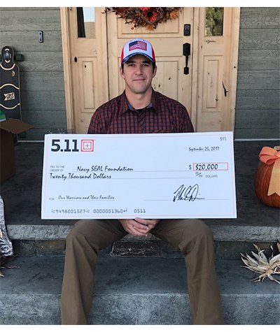 Andy Stumpf holding the $20,000 check from 5.11 to Navy SEAL Foundation