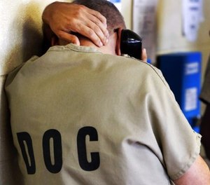 In this June 26, 2014, file photo, an inmate uses a phone at the Cook County Jail in Chicago. (AP Photo/Charles Rex Arbogast, File)