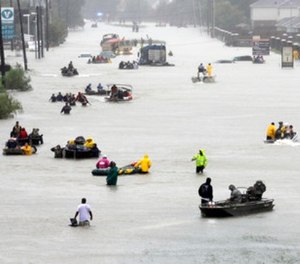 Rescue boats fill a flooded street as flood victims are evacuated as floodwaters from Tropical Storm Harvey rise Monday, Aug. 28, 2017, in Houston.