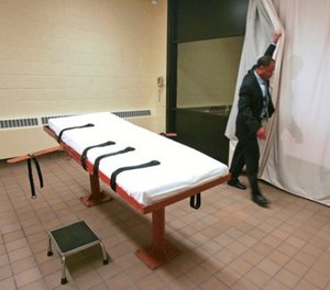 In this November 2005 file photo, Larry Greene, public information director of the Southern Ohio Correctional Facility, demonstrates how a curtain is pulled between the death chamber and witness room at the prison in Lucasville, Ohio.