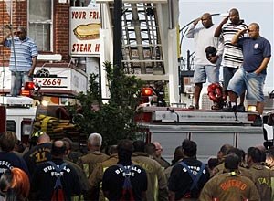 Buffalo firefighters salute as they remove bodies of fellow firefighters. (AP Photo/ David Duprey)