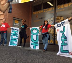 Four activists who chained themselves to each other outside an Ariz. jail entrance were arrested Wednesday.