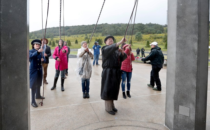 Members of passenger families, friends and volunteer repesentatives pull the ropes to ring the chimes at the dedication of the 93-foot tall Tower of Voices on Sunday, Sept. 9, 2018 at the Flight 93 National Memorial in Shanksville, Pa. The tower contains 40 wind chimes representing the 40 people that perished in the crash of Flight 93 in the terrorist attacks of Sept. 11, 2001.(AP Photo/Keith Srakocic, Pool)