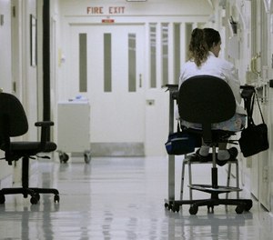 Medical worker Theresa Wilks keeps a vigil outside an isolation cell containing an inmate who authorities fear might attempt suicide, at California State Prison, Sacramento, in Folsom, Calif.