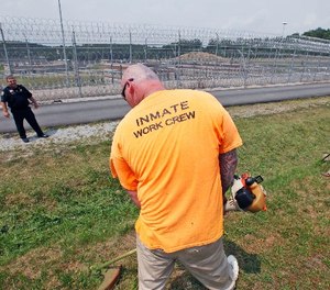 In this Tuesday, July 3, 2012 photo, Lt. Nate Kendrick, left, watches a work crew at the maximum-security Mount Olive Correctional Center in Mount Olive, W.Va.