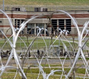 In this Tuesday, July 3, 2012 photo, inmates walk in the yard in front of a cellblock at the maximum-security Mount Olive Correctional Center in Mount Olive, W.Va. (AP Photo/Steve Helber)