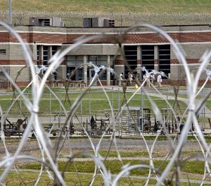 In this Tuesday, July 3, 2012 photo, inmates walk in the yard in front of a cellblock at the maximum-security Mount Olive Correctional Center in Mount Olive, W.Va. (AP Photo/Steve Helber)