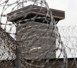 This Tuesday, July 3, 2012 photo shows coils of razor wire and a guard tower at the maximum-security Mount Olive Correctional Center in Mount Olive, W.Va.