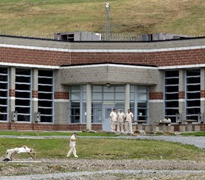 In this Tuesday, July 3, 2012 photo, inmates mill around the yard in front of a cellblock at the maximum-security Mount Olive Correctional Center in Mount Olive, W.Va.