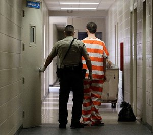 In this Feb. 21, 2013, file photo, an inmate at the Madera County, Calif., Jail is taken to an inmate housing unit in Madera, Calif.