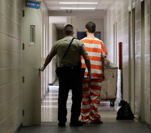 In this Feb. 21, 2013, file photo, an inmate at the Madera County, Calif., Jail is taken to an inmate housing unit in Madera, Calif.