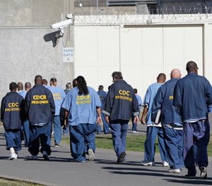 In this Feb. 26, 2013, file photo, inmates walk through the exercise yard at California State Prison Sacramento, near Folsom, Calif. (AP Photo/Rich Pedroncelli, File)