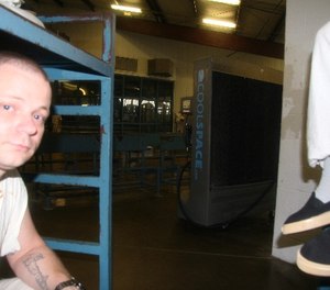 Inmate Doug Gore, 35, of Silsbee, Texas, sits on his bunk Friday, June 20, 2014, near a cooling fan recently installed at the Texas Department of Criminal Justice Holliday Unit near Huntsville, Texas.