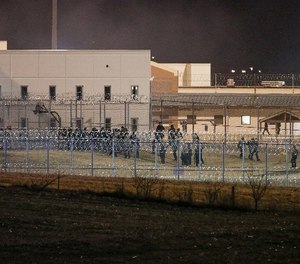 Security forces in riot gear escort prisoners from a courtyard behind razor wire at the Tecumseh State Correctional Institution in Tecumseh, Neb., Thursday, March 2, 2017, where dozens of inmates congregated after refusing to return to their cells.