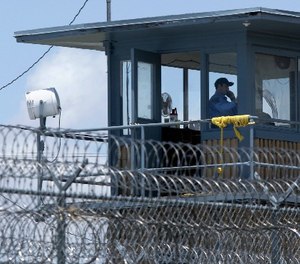 In this photo taken May 13, 2011 file photo, a guard is shown in a tower at the Arkansas Department of Correction Tucker Unit near Tucker, Ark.