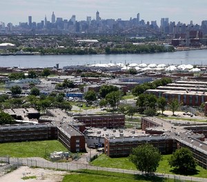 In a June 20, 2014, file photo, the Rikers Island jail complex stands in New York with the Manhattan skyline in the background. (AP Photo/Seth Wenig, File)