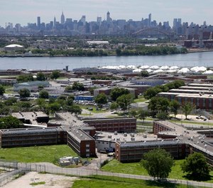 In a June 20, 2014, file photo, the Rikers Island jail complex stands in New York with the Manhattan skyline in the background.