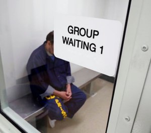 An inmate waits for his appointment in a holding room at a mental health treatment unit.