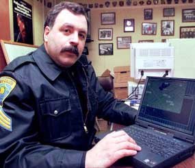 A State College (Pa.) Police Officer demonstrates his laptop computer that he uses to assist in fighting crime.
