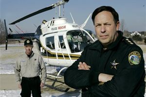 Countryside, Ill., police chief Tim Swanson, right, and pilot Kurt Kaiser stand near an OH-58 helicopter that the city received from the U.S. military as part of a surplus giveaway in Monee, Ill., Friday, Jan. 26, 2007. (AP Photo/Charles Rex Arbogast)