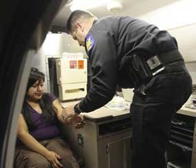 In this Sept. 11, 2009 photo, Phoenix Police Department Officer James Lawler, of the DUI Squad, prepares to draw blood from an alleged extreme DUI suspect as he works out of a mobile DUI processing van in Phoenix.