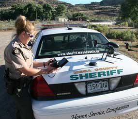 Deputy Amanda Hill of the Mesa County Sheriff's Office in Colorado prepares to use a Draganflyer X6 drone equipped with a video camera to help search for a suspect in a knife attack in Mesa County, Colo. Civilian cousins of the unmanned military aircraft that have been tracking and killing terrorists in the Middle East and Asia are being sought by police departments, border patrols, power companies, news organizations and others who want a bird's-eye view.