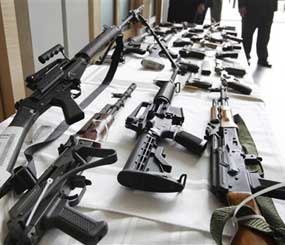 Various guns are displayed at the Chicago FBI offices, Thursday, July 22, 2010. Federal and local authorities say they were seized after 23 people were arrested in and around Chicago by undercover officers. More than 60 guns were seized and the defendants charged with various state and federal weapons and drug violations.