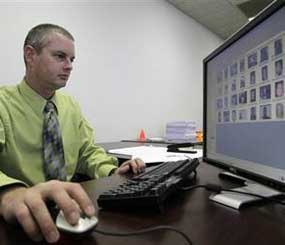 Stephen Lamm, supervisor with the ID Fraud Unit of the North Carolina Department of Motor Vehicles looks through photos in the facial recognition system Thursday, Sept. 24, 2009 in Raleigh, N.C. (AP Photo/Gerry Broome)