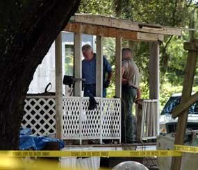 Glynn County investigators work on the porch of the house at New Hope Mobile Home Park in Brunswick, Ga. where seven people were found slain Saturday morning Aug. 29, 2009. Seven people were found slain and two critically injured Saturday at a mobile home located on a historic plantation in southeastern Georgia, police said. (AP Photo)