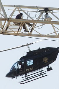 A homicide suspect identified as Carl Roland is buzzed by a law enforcement helicopter atop an 18-story construction crane in the Buckhead area of Atlanta in May of 2005.