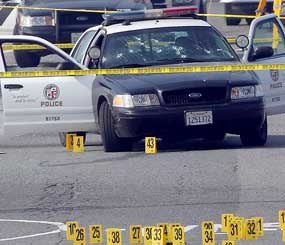 Police tape cordons off the area surrounding an LAPD squad car riddled with bullet holes in the aftermath of an alleged ambush attack by ex-cop Christopher Jordan Dorner.