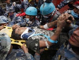 A teen is carried on a stretcher after being rescued by Nepalese policemen and U.S. rescue workers from a building that collapsed during the Nepal 2015 earthquake.