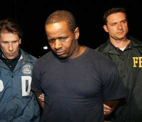 James Cromitie, center, is escorted by an NYPD officer and an FBI agent after being arrested for plotting to bomb New York synagogues and shoot down military aircraft. (AP Photo)