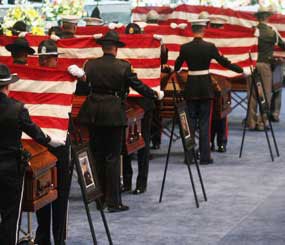 Honor guard fold flags at the 2009 funeral held for the four slain Oakland police officers (AP photo)