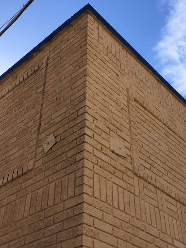 View of metal anchoring plates bolted to front side of parapet wall.