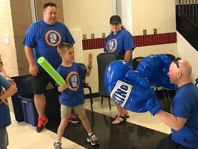 Cabot PD staff and volunteers help cadets practice baton skills.