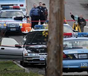 Police work at the scene where a man suspected of gunning down four police officers was shot and killed by a lone Seattle patrol officer who came across the stolen car in a south Seattle neighborhood about 2:45 a.m.