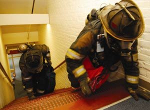 Photo Worcester Polytechnic InstituteFirefighters crawl up stairs in the Worcester Polytechnic Institute's electrical engineering building during training last year. They have the 3D location transmitters on their turnout gear, as does the "lost" firefighter they are searching for. The WPI system led them to the lost firefighter and allowed them to rescue him on one tank of air.