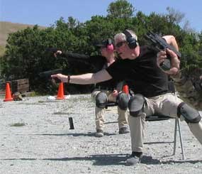 Here I am during a drill to simulate responding to a sudden ambush attack in a restaurant or some other place where you'd be seated. After drilling the two body shots, I had to drop the magazine (you can see the mag mid-flight to the gravel), reload, and then do the head shot, nailing it directly between the eyes.