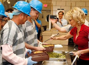 Actress Pamela Anderson, right, serves the first all-vegetarian meal to inmates at the Maricopa County Jail, making it the first jail in the country to go entirely vegetarian, Wednesday, April 15, 2015, in Phoenix.