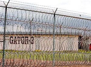 This April 22, 2009, file photo, shows a prisoner, far right, seen behind layers of wire razor fencing at the Louisiana State Penitentiary at Angola, La. (AP Photo/Judi Bottoni, File)