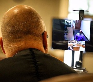 Kern County Superior Court Judge David Wolf speaks with an inmate at Pelican Bay State Prison, 600 miles away via an Oct. 16 video arraignment at Delano Prison Court (illustration).