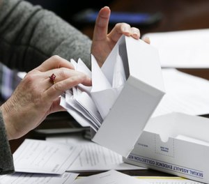 Rep. Marion O'Neill looks through a sexual assault evidence collection kit during testimony on work done by the Working Group on Untested Rape Kits.