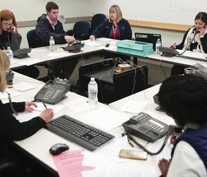 People answer phones at the call center for Hepatitis A questions at the Utah County Health Department.