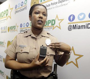 Miami-Dade Police Department PIO Marjorie Eloi shows how to turn on and off a body camera, which 1,000 officers will begin using over the next few months, during a news conference, Thursday, April 28, 2016. (AP Image)
