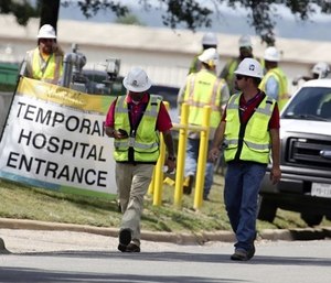 Construction workers leave a temporary entrance to Coryell Memorial Healthcare System hospital where an explosion in a building under construction injured several people, and knocked power out for a large portion of the city. (Photo/AP)
