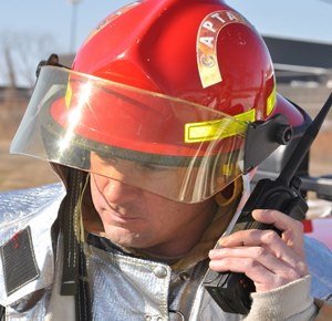Mike Fortmann of the 128th Air Refueling Wing Fire Department, Milwaukee, communicates with headquarters via a handheld radio during a training exercise.